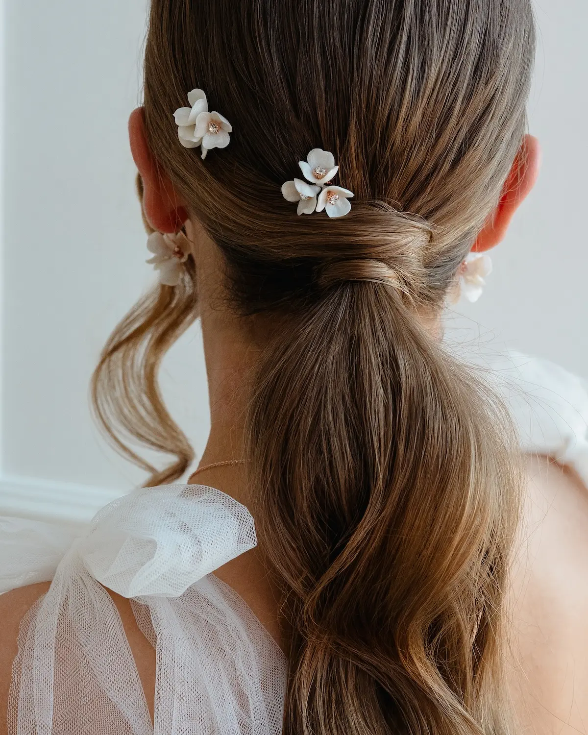 Moderne Brautfrisur als Ponytail mit Bl&uuml;ten Haarnadeln CLEO in der Farbe Ros&eacute;gold von Sternenauge
