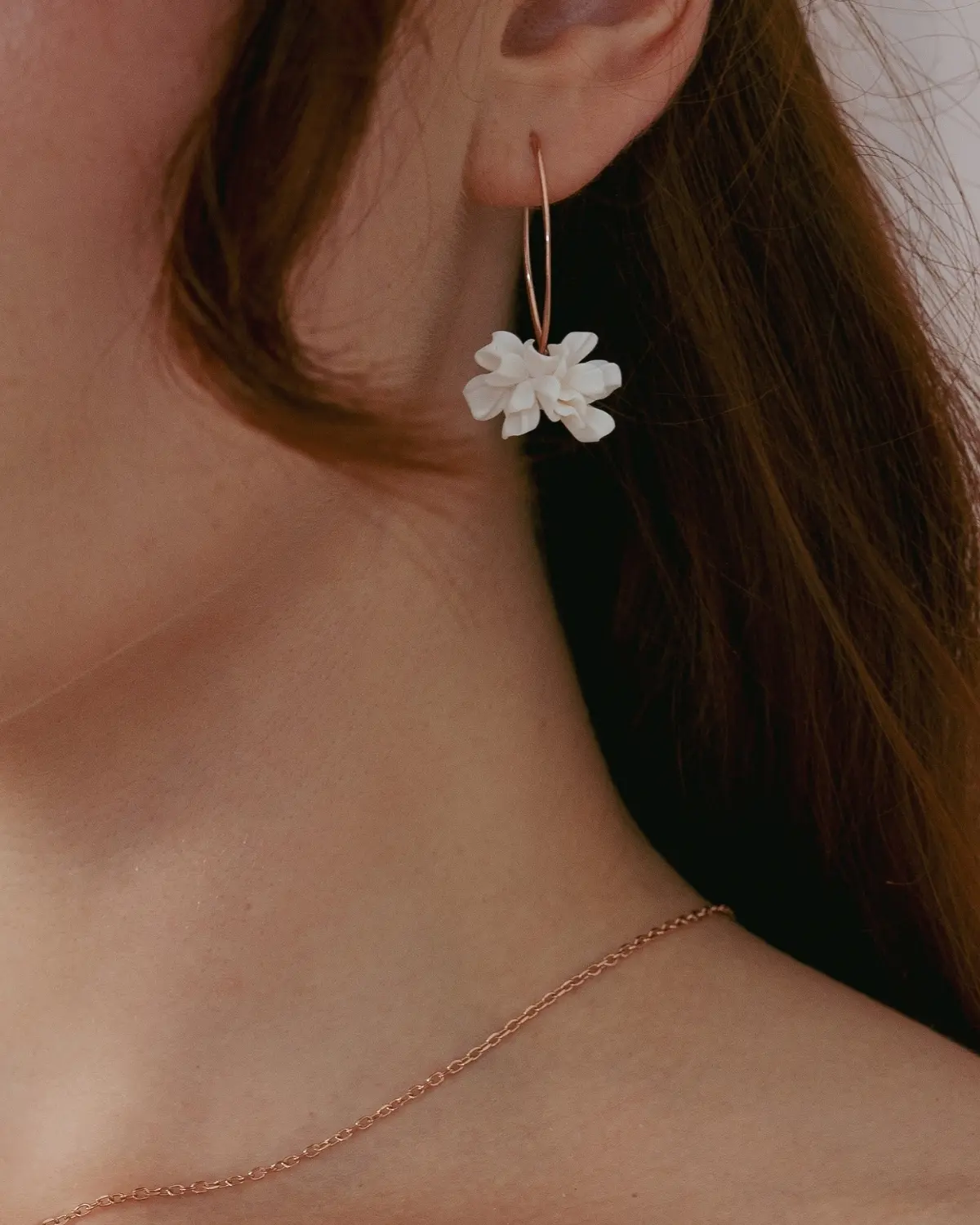 Ansicht der Valeria Ohrhänger am Ohr einer Braut, kombiniert mit einer feinen Halskette in Roségold-Ton. Perfekt abgestimmter Brautschmuck für das Dekolleté am Hochzeitstag.