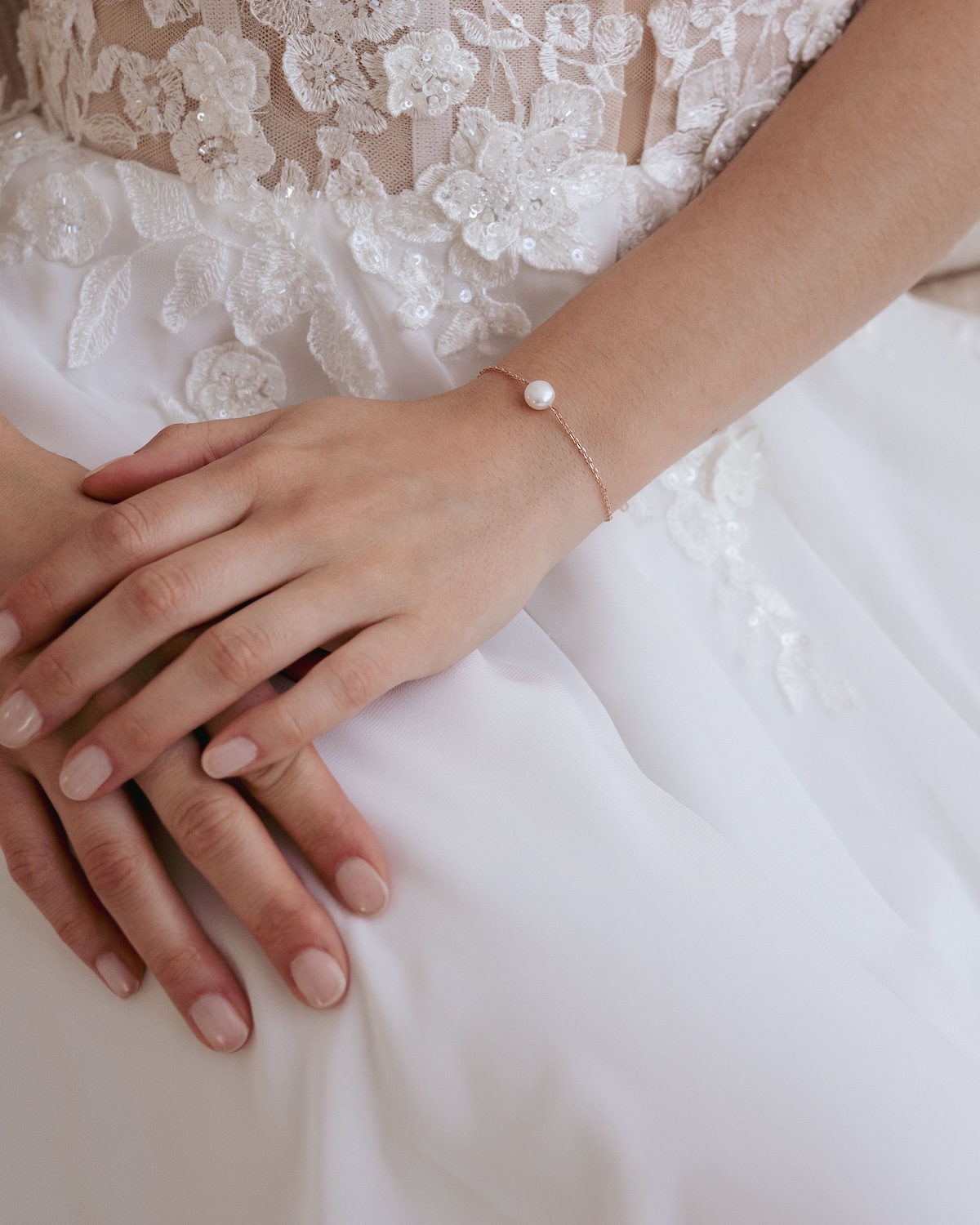 Armband mit Perle am Handgelenk zum Brautkleid
