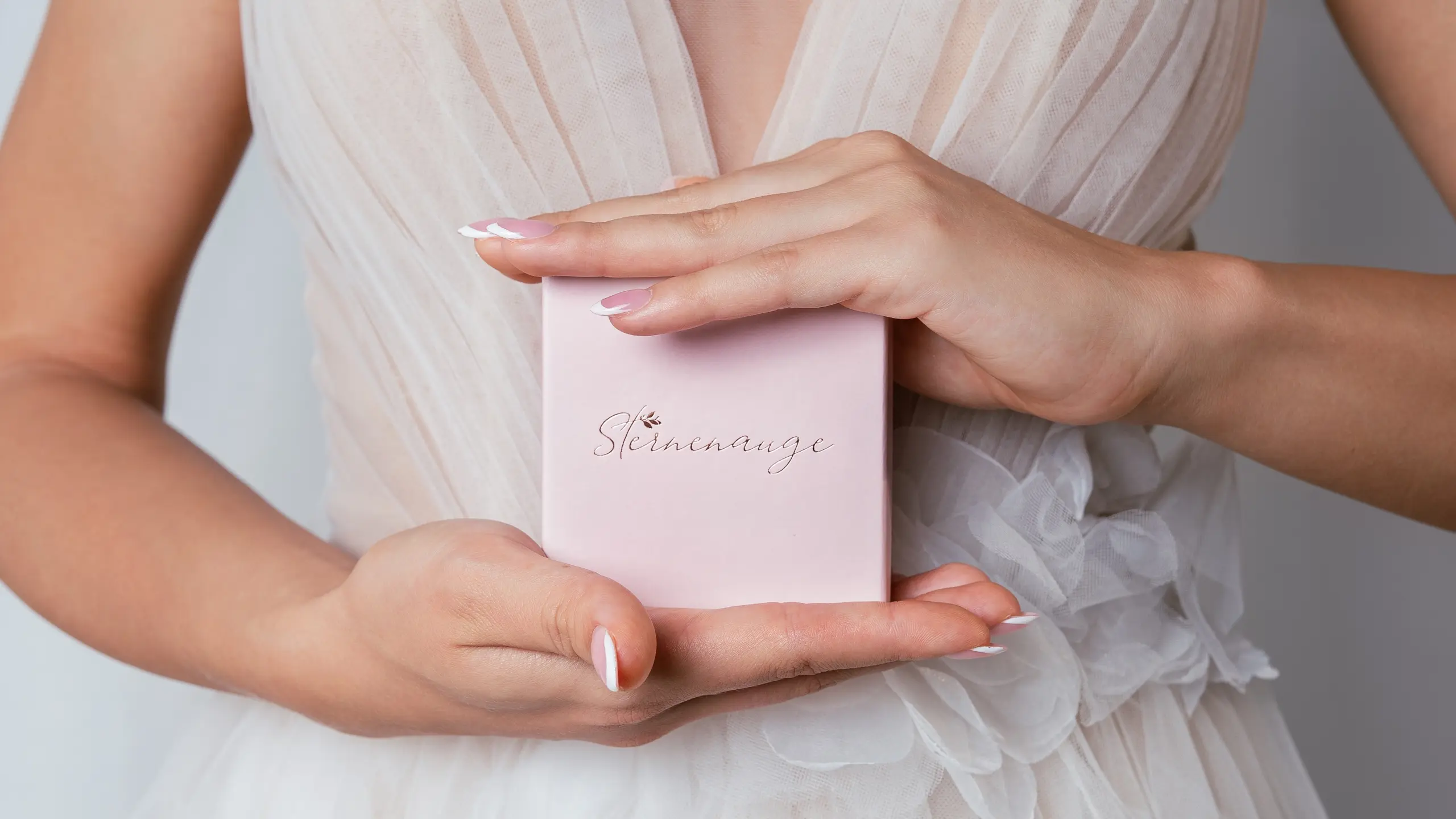 Braut hält elegante Schmuckbox von Sternenauge in den Händen
