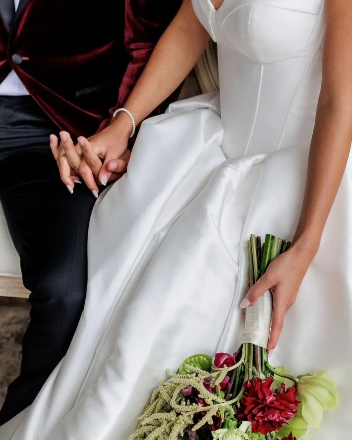 Hochzeitsfoto mit dem handgefertigten Perlenarmband Annouk aus Muschelkernperlen und 925 Sterling Silber zu einem modernen, cleanen Satin-Brautkleidmit Korsagen-Oberteil neben dem Bräutigam